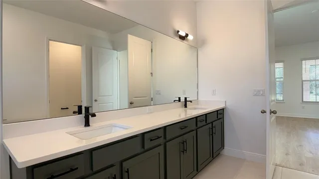 a bathroom with a double vanity sink and a mirror