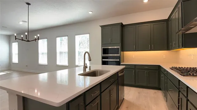 a kitchen with granite countertop a sink a counter top space and cabinets