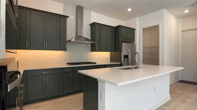 a kitchen with stainless steel appliances a sink and a refrigerator