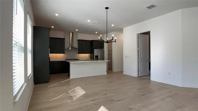 a large room with a large window and kitchen view
