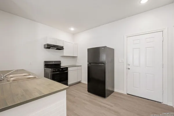a kitchen with a refrigerator and a sink