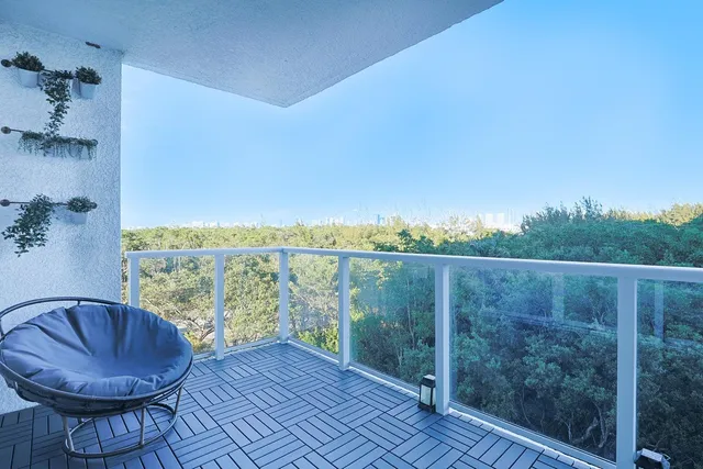 a view of a balcony with furniture and a floor to ceiling window
