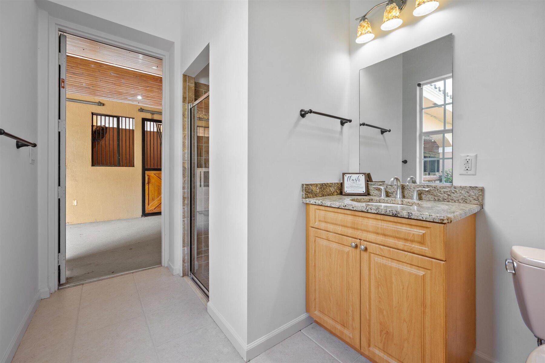 3935 Hanover Circle Loxahatchee, FL 33470 - Photo 15 of 29 a en suite bathroom with a granite countertop sink and a mirror
