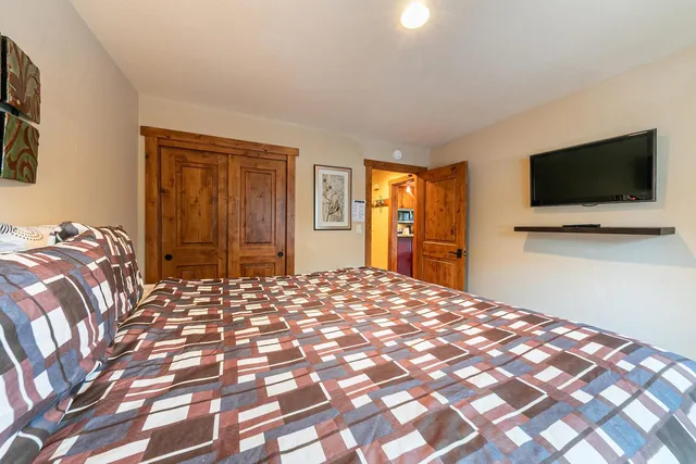 a bedroom with a bed and a flat screen tv