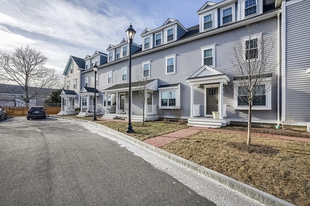 a front view of a house with a large tree