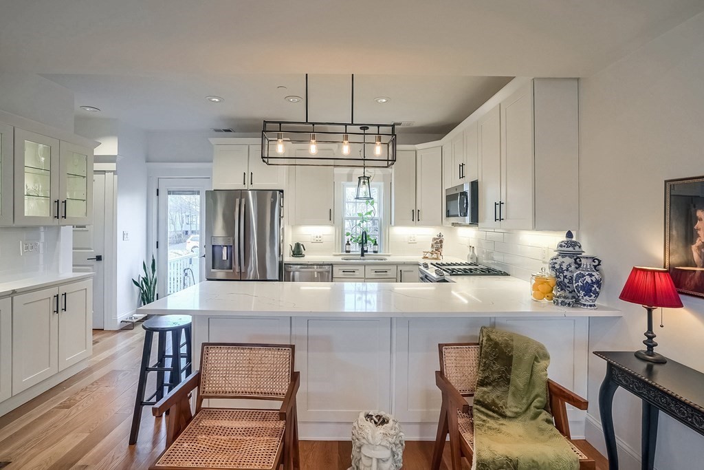 12 South Mason Street, Unit 3 Salem, MA 01970 - Photo 8 of 35 a kitchen with stainless steel appliances granite countertop a kitchen island hardwood floor and a sink