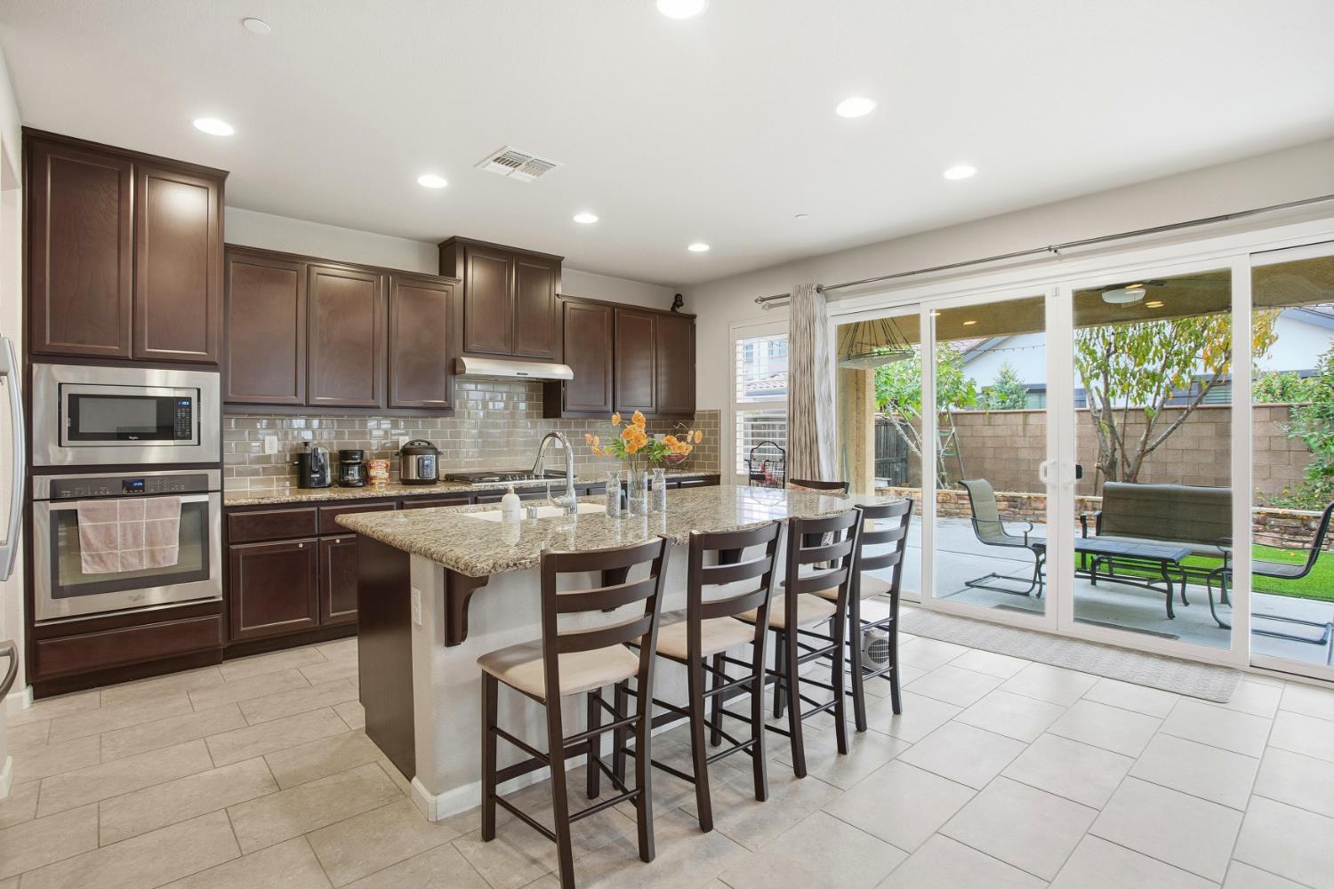 9729 Allen Ranch Way Elk Grove, CA 95757 - Photo 7 of 36 a kitchen with kitchen island a large counter top space appliances and cabinets
