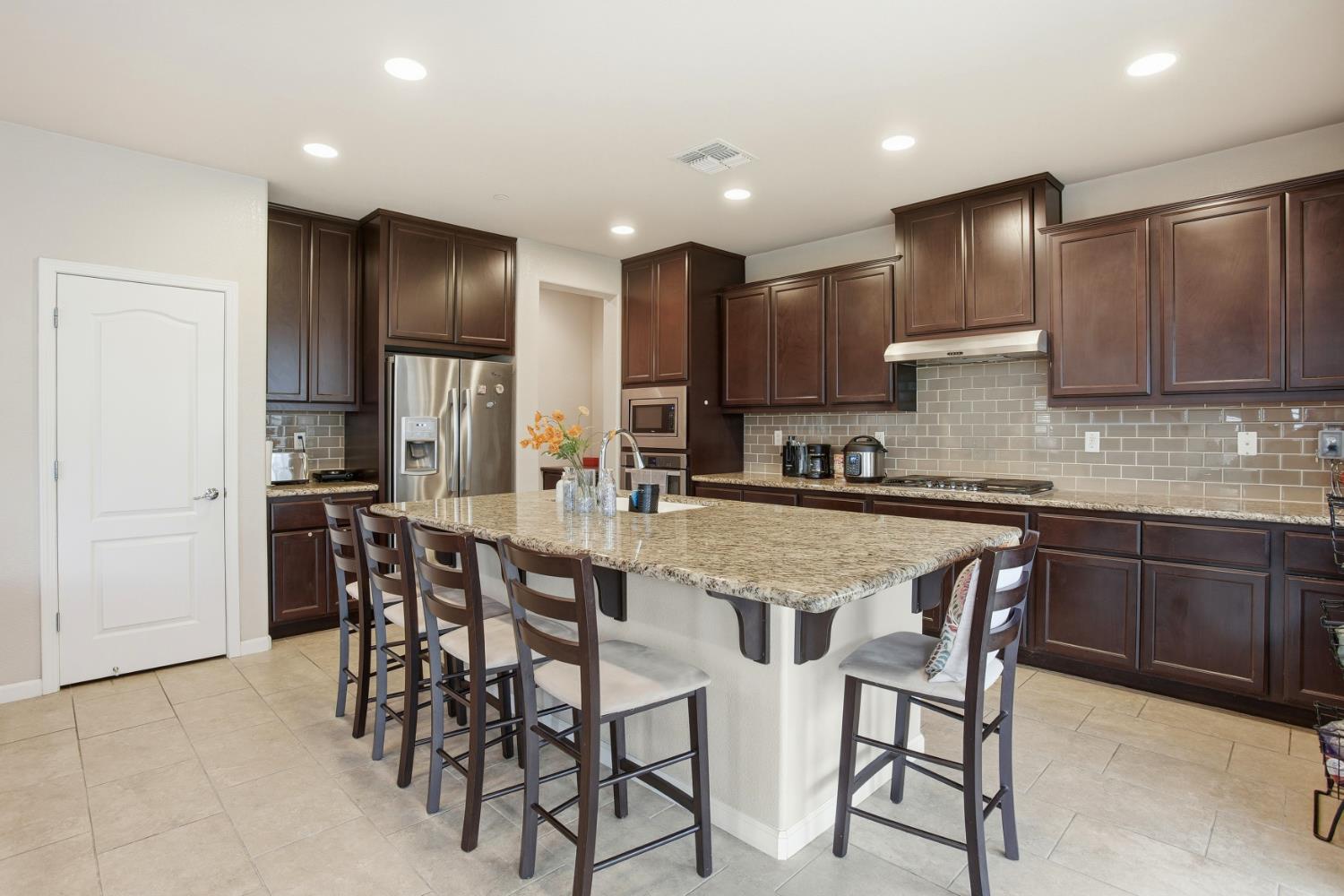 9729 Allen Ranch Way Elk Grove, CA 95757 - Photo 8 of 36 a kitchen with stainless steel appliances granite countertop table chairs sink and cabinets