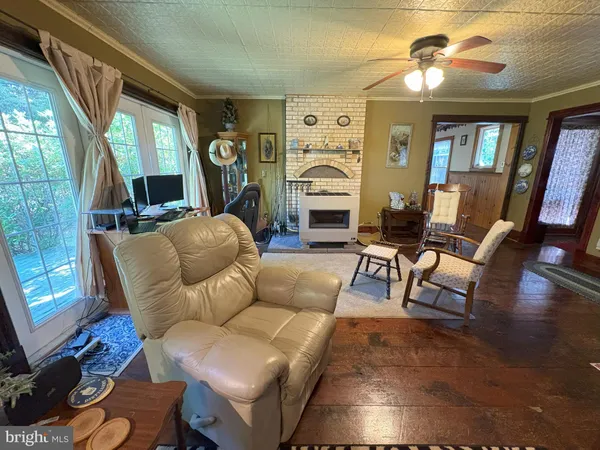 a living room with furniture a fireplace and a floor to ceiling window