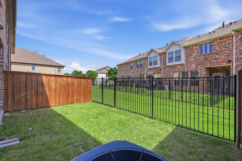 519 Sequoia Street Allen, TX 75002 - Photo 35 of 38 Fenced backyard featuring a wood privacy fence and black wrought iron fence, with a grass lawn