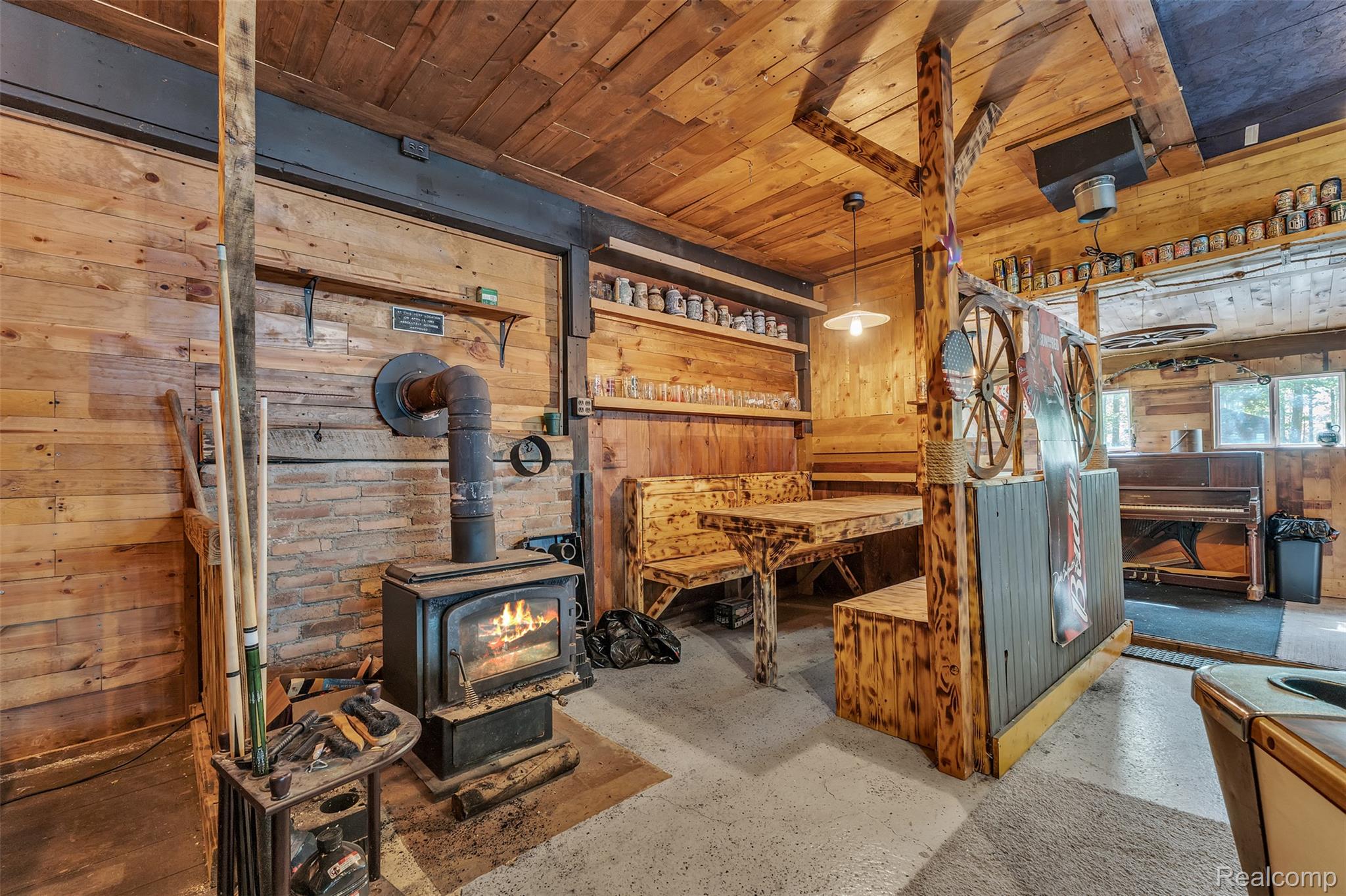 1345 Ives Road Mason, MI 48854 - Photo 51 of 92 Misc room featuring wooden walls, wooden ceiling, a wood stove, and concrete flooring