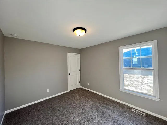 an empty room with windows and entrance