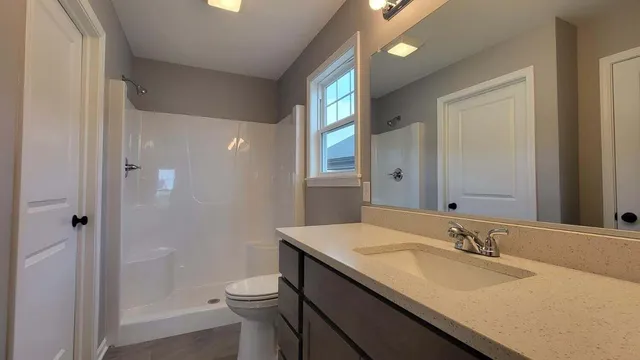 a bathroom with a granite countertop sink toilet and shower
