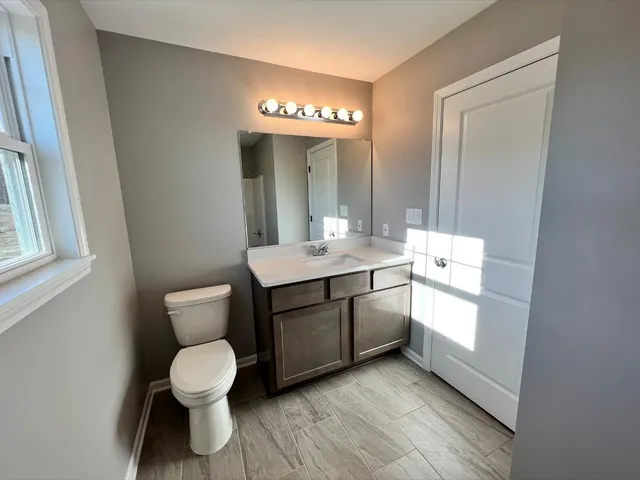 a bathroom with a toilet sink and mirror