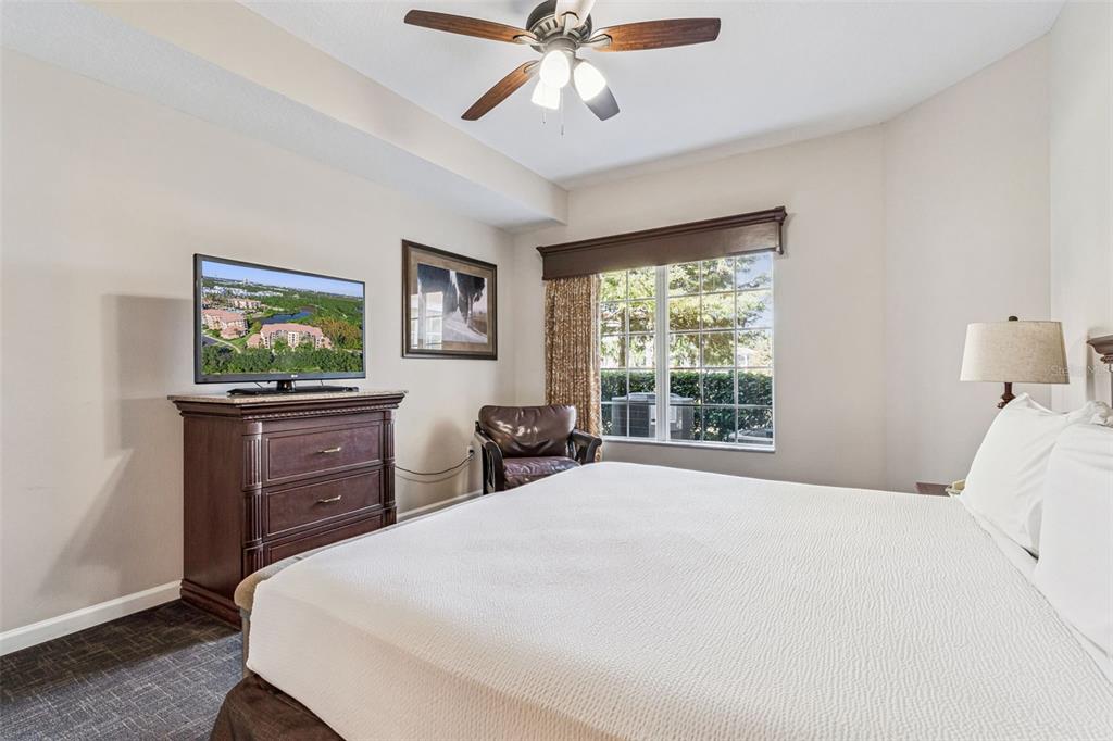 8801 Worldquest Boulevard, Unit 4108 Orlando, FL 32821 - Photo 25 of 85 a bedroom with a bed and dresser with floor to ceiling window