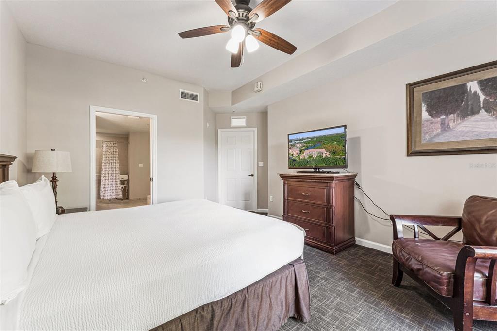 8801 Worldquest Boulevard, Unit 4108 Orlando, FL 32821 - Photo 27 of 85 a bedroom with a bed and a chandelier