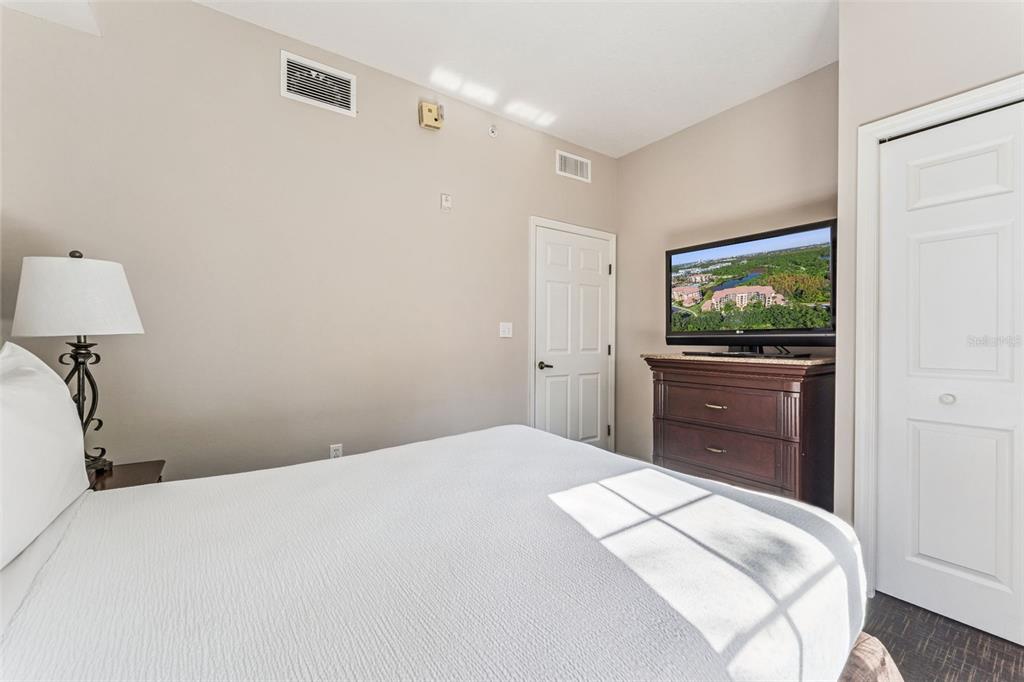 8801 Worldquest Boulevard, Unit 4108 Orlando, FL 32821 - Photo 29 of 85 a bedroom with a bed and a flat tv screen