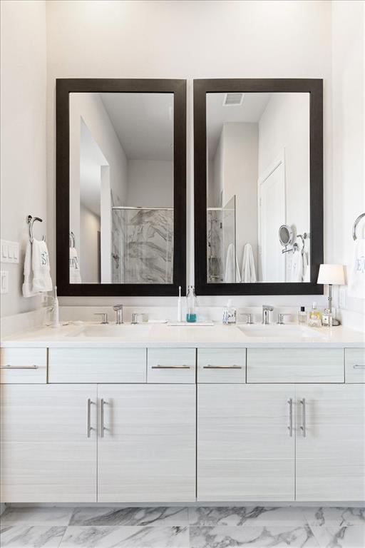 4129 Runyon Road Addison, TX 75001 - Photo 25 of 38 Bathroom featuring light marble finish flooring, double vanity, and a marble finish shower