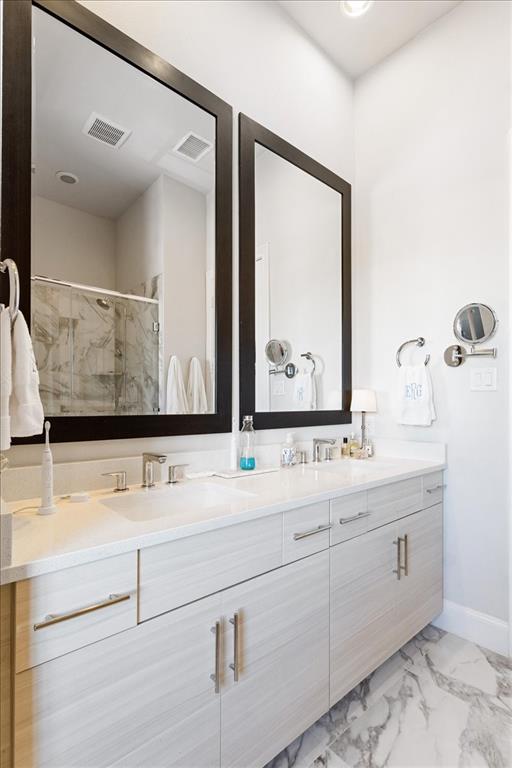 4129 Runyon Road Addison, TX 75001 - Photo 28 of 38 Bathroom with double vanity, a marble finish shower, and light marble finish floors