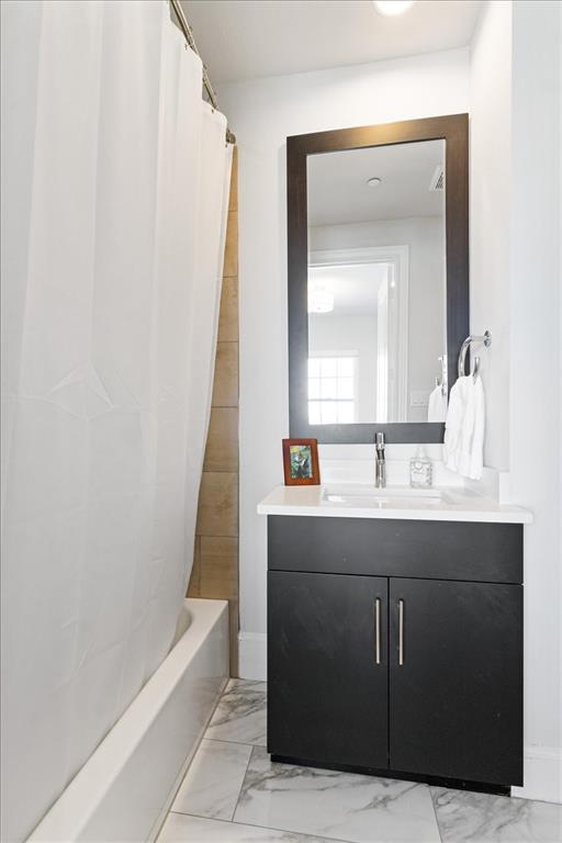 4129 Runyon Road Addison, TX 75001 - Photo 31 of 38 Full bathroom featuring vanity, light marble finish floors, and shower / tub combo with curtain