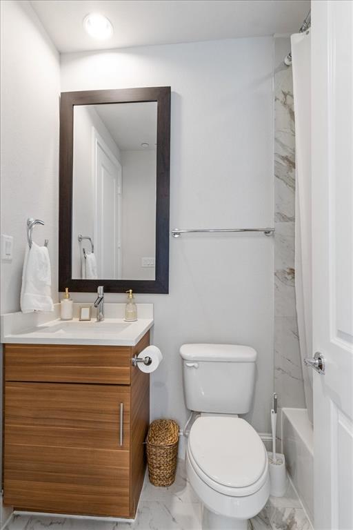 4129 Runyon Road Addison, TX 75001 - Photo 8 of 38 Bathroom with vanity, shower / bathtub combination with curtain, and light marble finish flooring