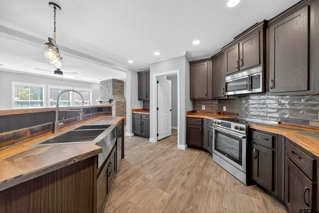 a kitchen with stainless steel appliances granite countertop a sink stove and refrigerator