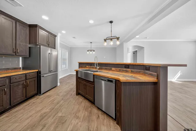 a kitchen with stainless steel appliances granite countertop a sink a stove and a refrigerator