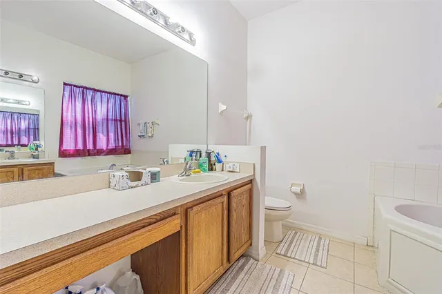 a bathroom with a sink a toilet a mirror and vanity