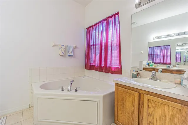 a bathroom with a sink vanity and a bathtub