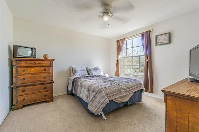 a spacious bedroom with a bed and a dresser