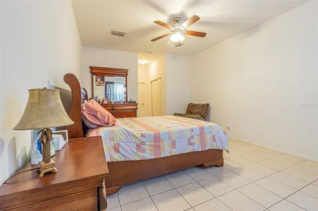 a bedroom with a bed and lamp on dresser