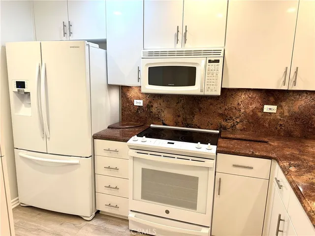 a kitchen with cabinets stainless steel appliances and a counter space