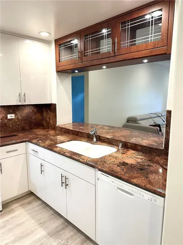 a kitchen with granite countertop stainless steel appliances sink and cabinets