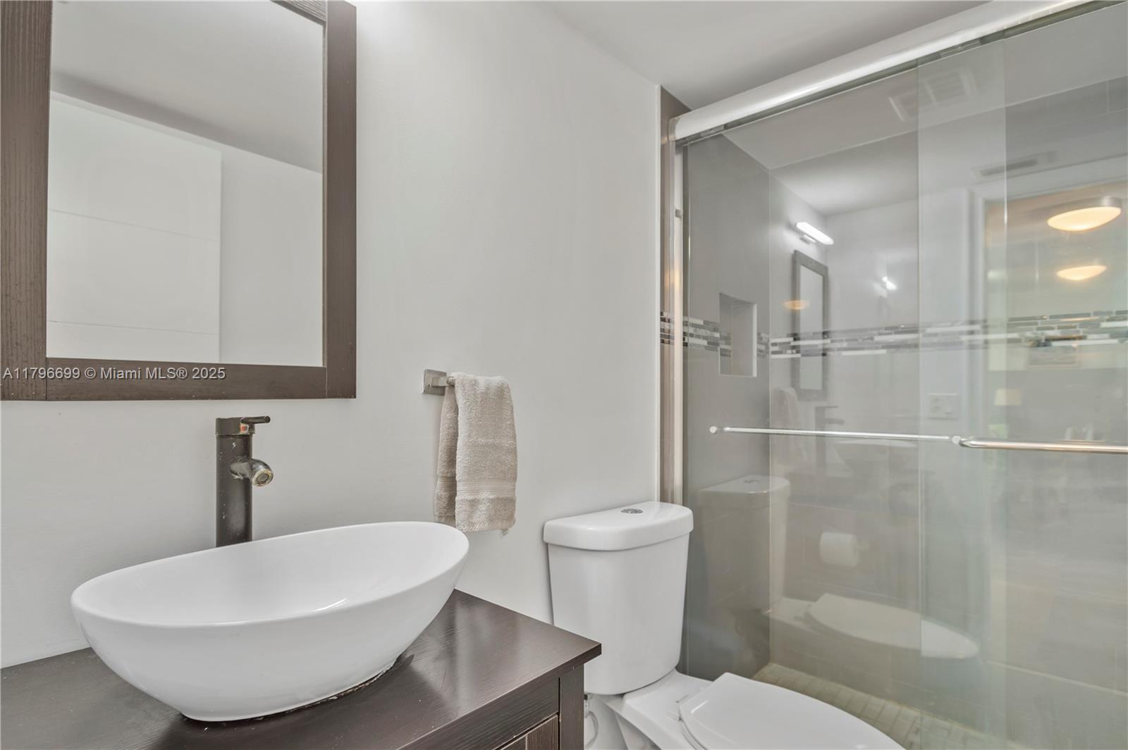 22053 Palms Way, Unit 106 Boca Raton, FL 33433 - Photo 12 of 17 a bathroom with a toilet and a mirror