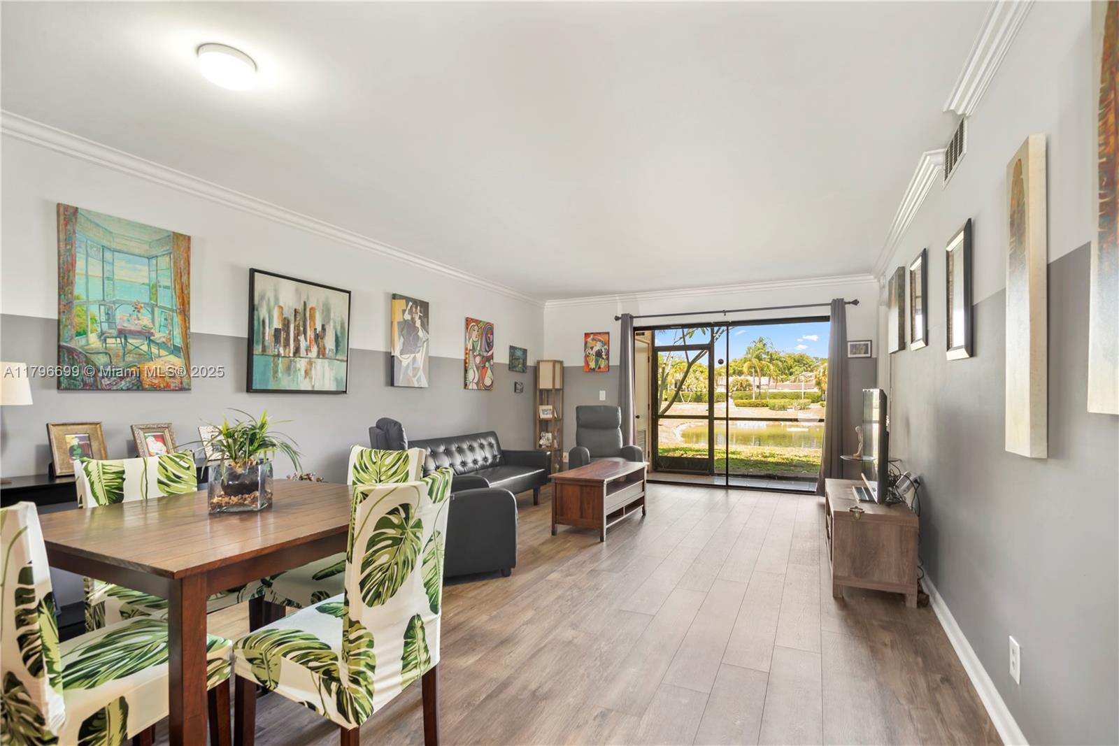 22053 Palms Way, Unit 106 Boca Raton, FL 33433 - Photo 4 of 17 a view of a livingroom with furniture a flat screen tv and wooden floor