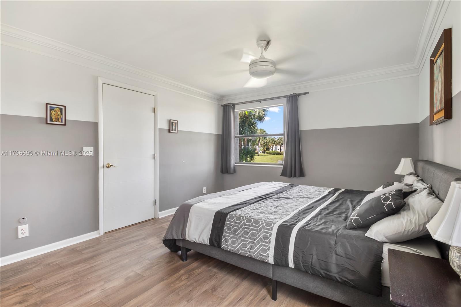 22053 Palms Way, Unit 106 Boca Raton, FL 33433 - Photo 10 of 17 a bedroom with a bed and wooden floor