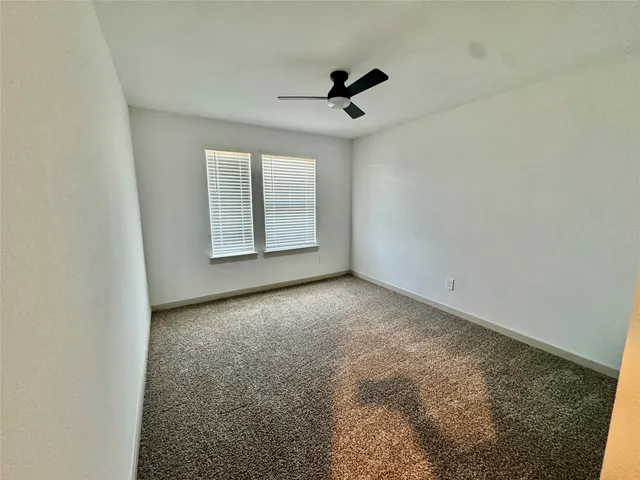 a view of a hallway with wooden floor and a bathroom