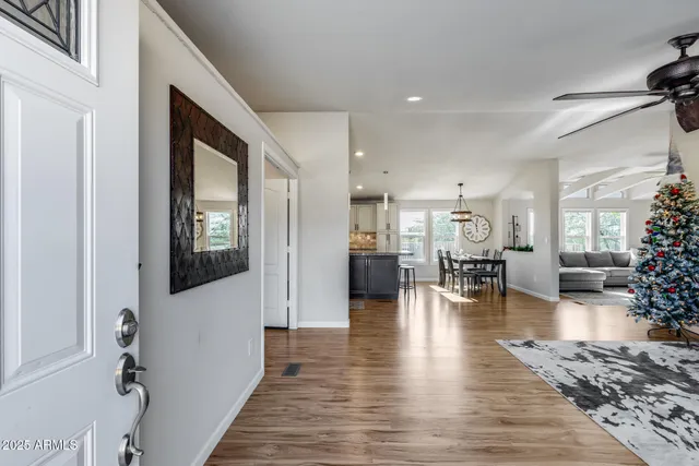 a view of a living room a hardwood floor and a ceiling fan