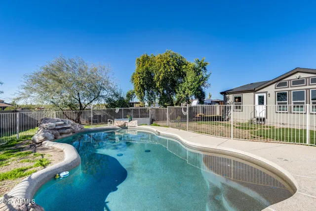 a view of a backyard with couches under an umbrella