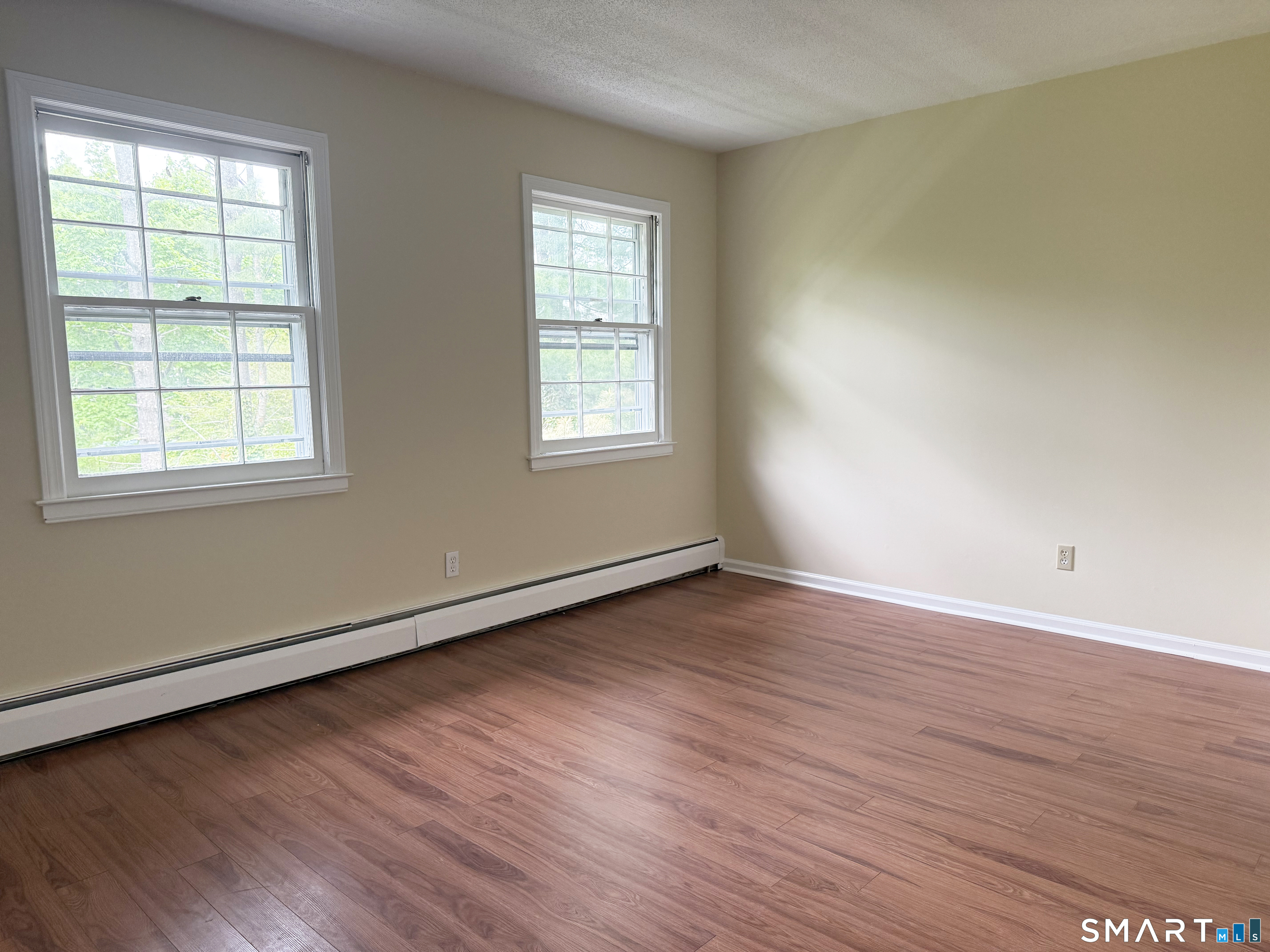 116 Commerce Street, Unit 5 Clinton, CT 06413 - Photo 10 of 18 an empty room with wooden floor and windows