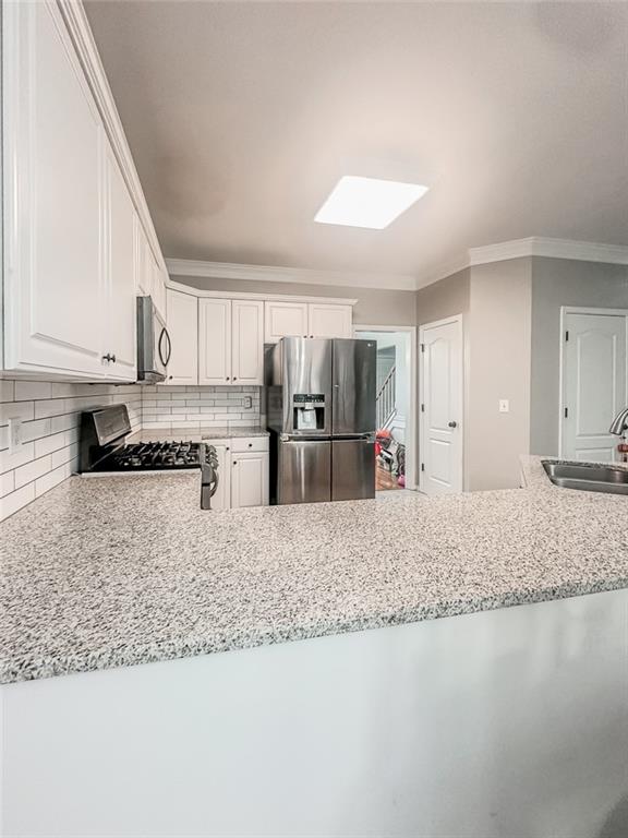 1485 Oglethorpe Run Lane Suwanee, GA 30024 - Photo 5 of 18 a large white kitchen with granite countertop a stove a sink and a refrigerator