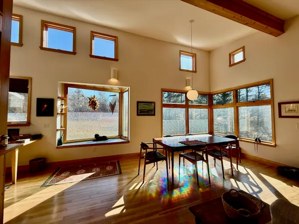 a view of a dining room with furniture a kitchen and chandelier