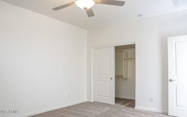 a view of a hallway with a ceiling fan