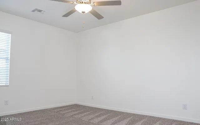an empty room with a chandelier fan