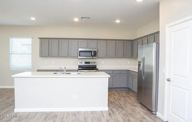 a kitchen with a refrigerator a sink and wooden cabinets