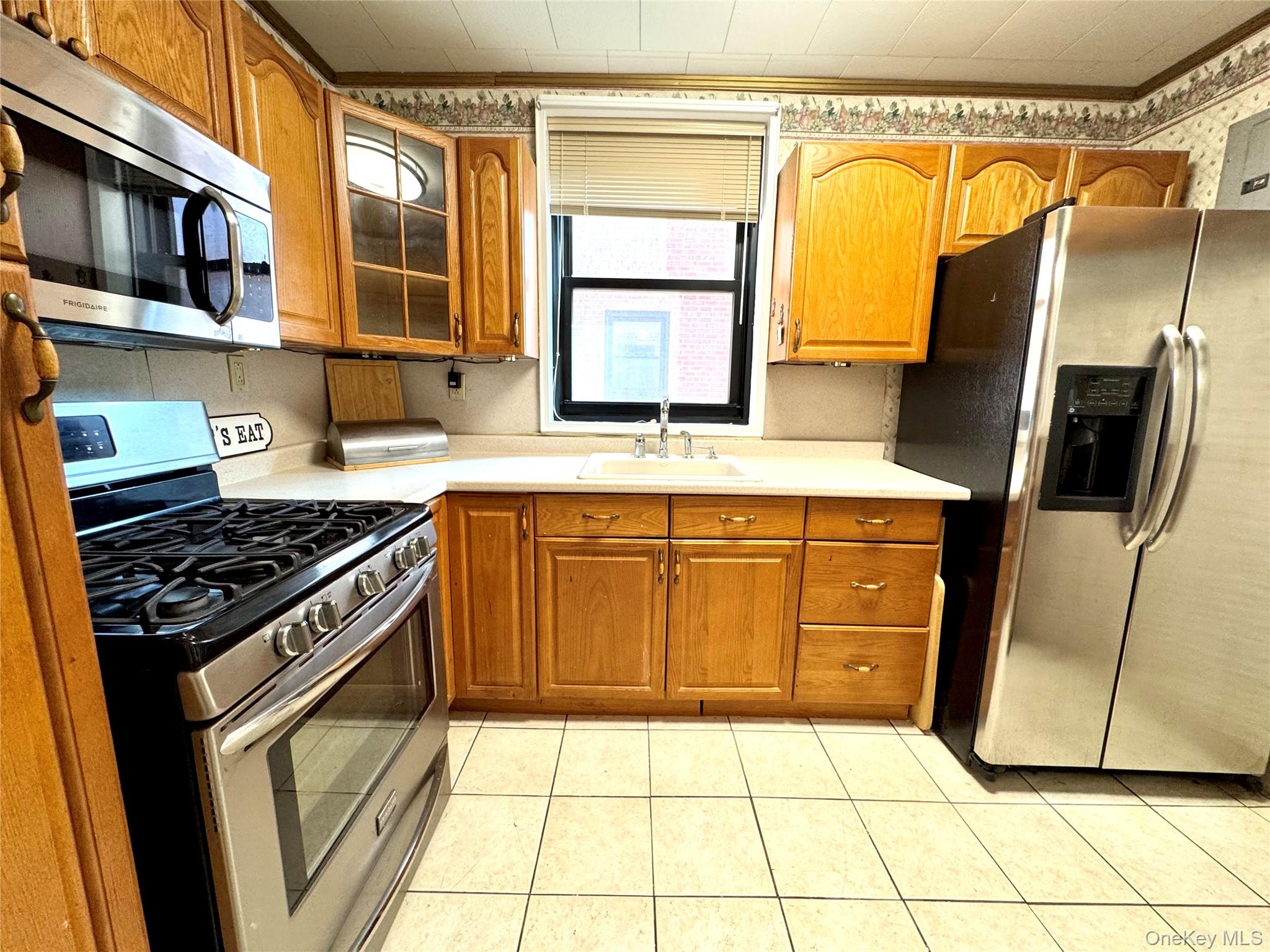 139-15 83rd Avenue, Unit 409 Queens, NY 11435 - Photo 16 of 38 a kitchen with stainless steel appliances granite countertop a stove a sink and a refrigerator