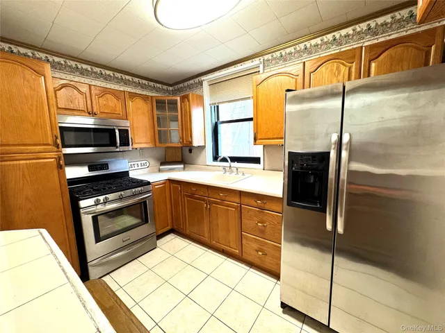a kitchen with stainless steel appliances granite countertop a refrigerator a stove and a sink with wooden floor