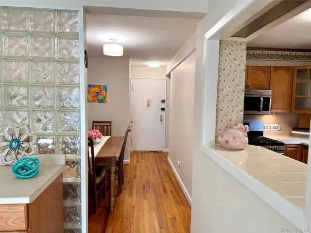 a dining room with stainless steel appliances furniture a rug and a kitchen view