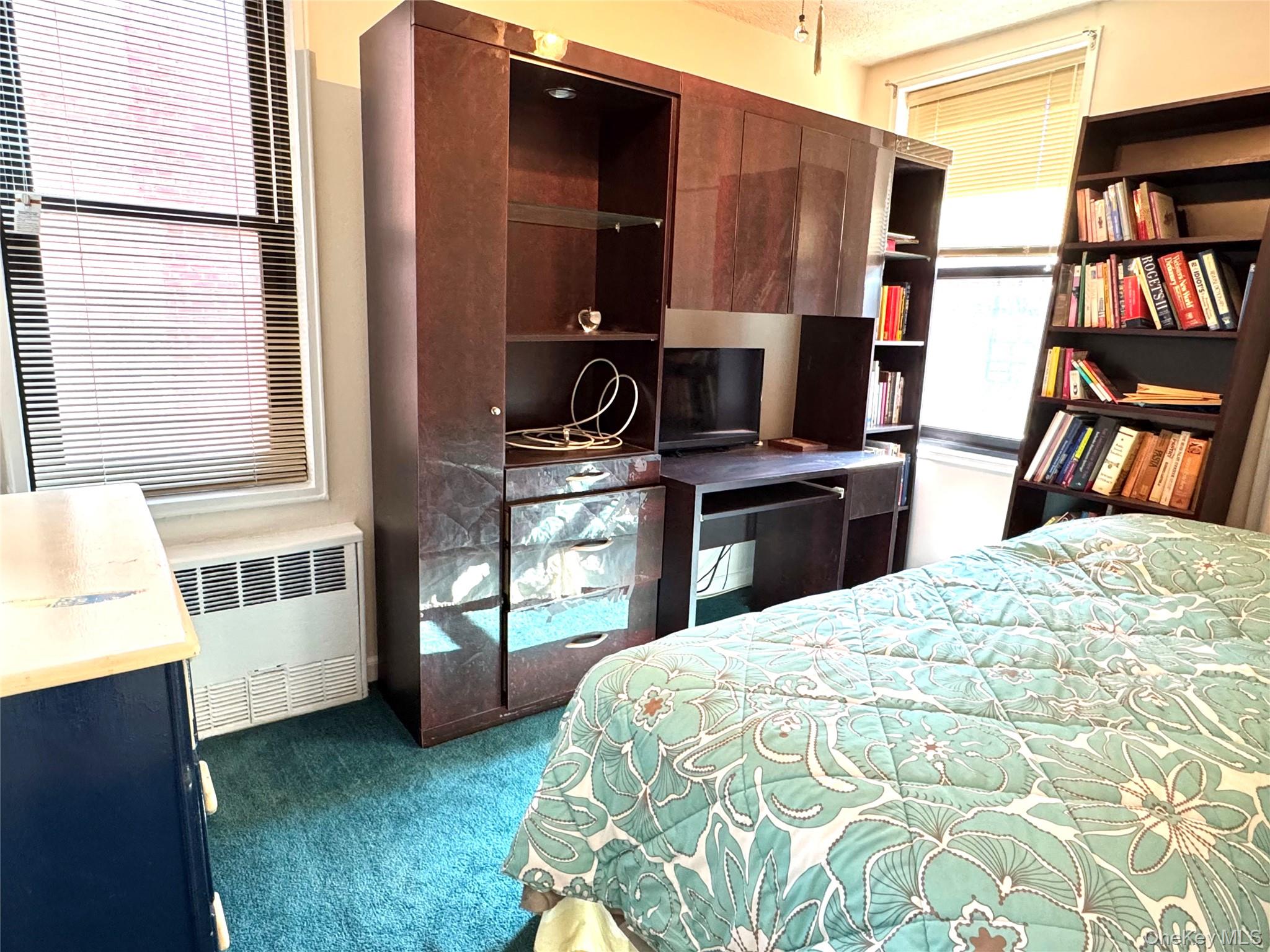 139-15 83rd Avenue, Unit 409 Queens, NY 11435 - Photo 34 of 38 a bedroom with a bed and a book shelf