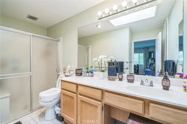 a bathroom with a sink a toilet a large mirror and shower